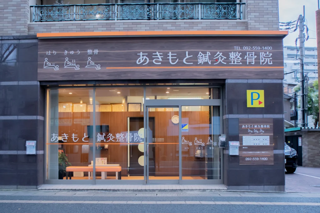 あきもと鍼灸整骨院の外観。ガラス張りの入口と院名を書いた看板